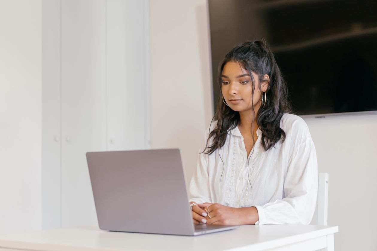 Woman focused on studying for an AI certification on her laptop